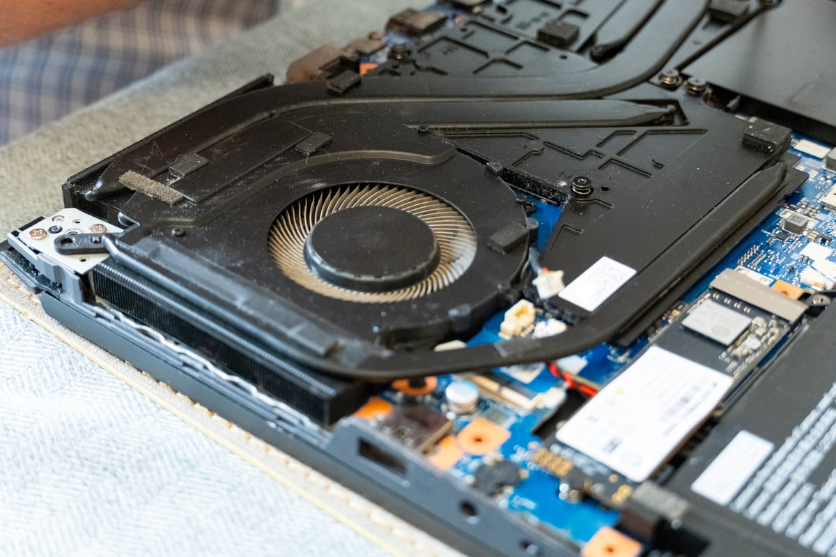 Opened laptop showing clean cooling fan and heat pipes after professional service